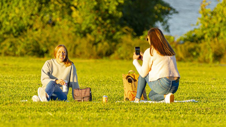 A girl takes a picture at a picnic