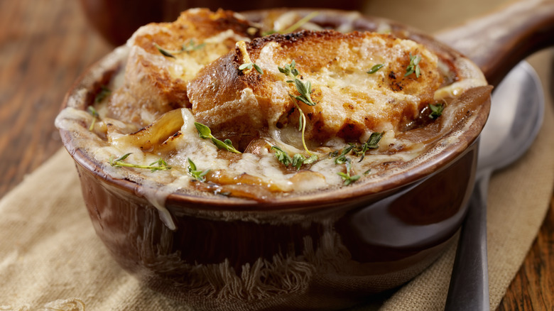 closeup of french onion soup in brown crock