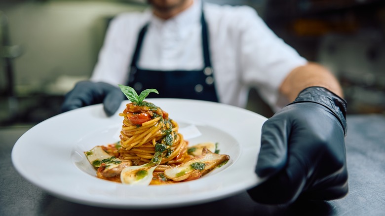 A chef presents a plate of food