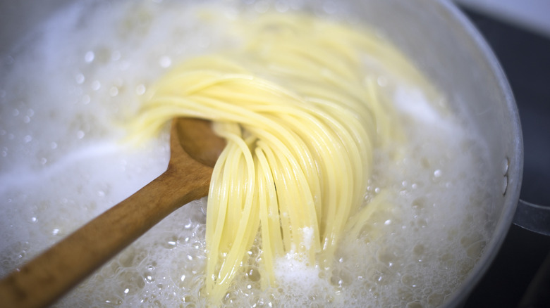 spaghetti noodles cooking in boiling water