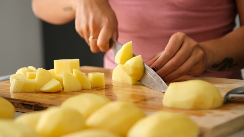 Cutting potatoes on cutting board