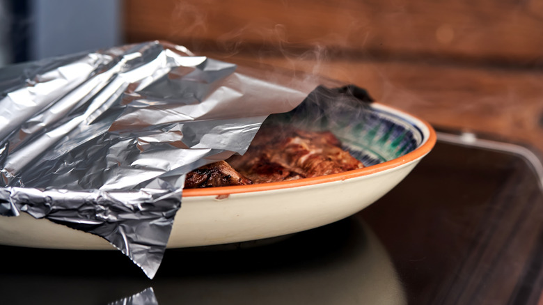 foil covering a plate of bbq