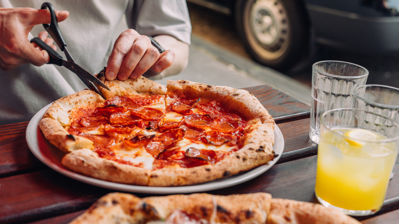 Cutting pizza with scissors