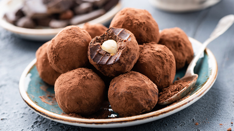 Pile of chocolate truffles, one with a bite