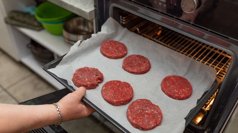 Burger patties being placed in the oven