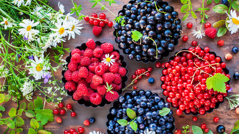 Berries in bowls surrounded by flowers