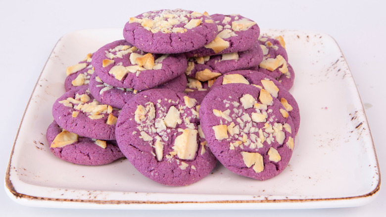 plate of purple cookies garnished with nuts