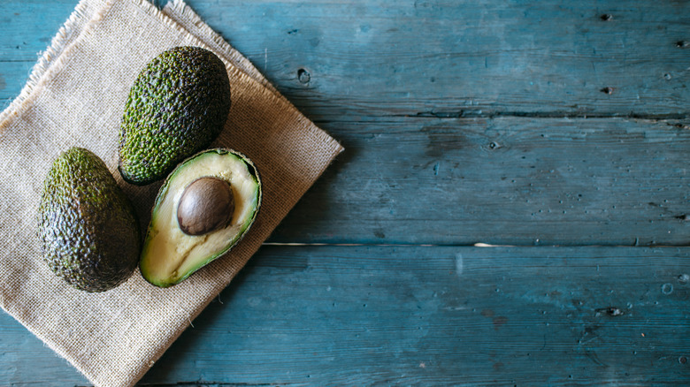 Ripe avocados on a turquoise table