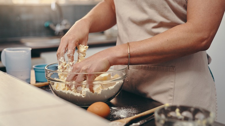 A woman preparing ingredients for baking in a bowl