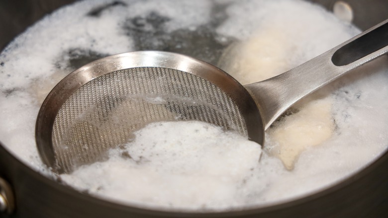 Skimming chicken foam from a pot
