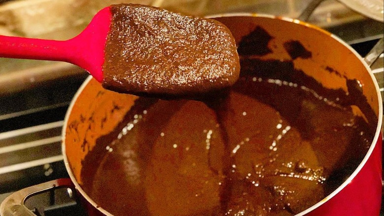 A large batch of chocolate roux in a Dutch oven that's been cooked in the oven