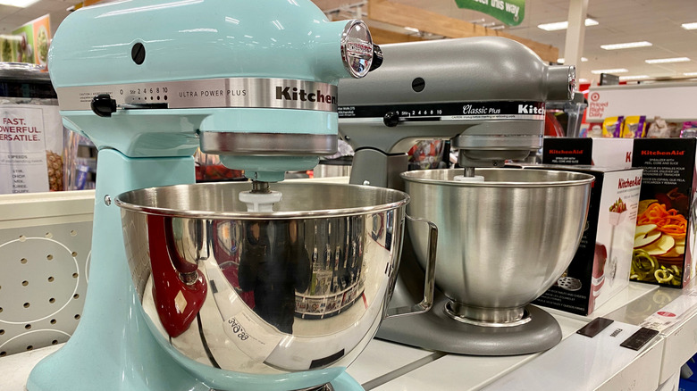 Two KitchenAid stand mixers on a store shelf