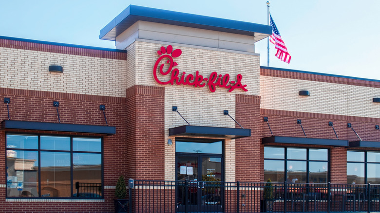 a Chick-fil-A restaurant storefront with an American flag at the top