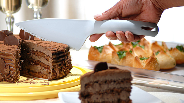 knife slicing chocolate cake