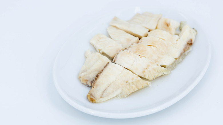 Steamed fish filet that has been slice on a white plate