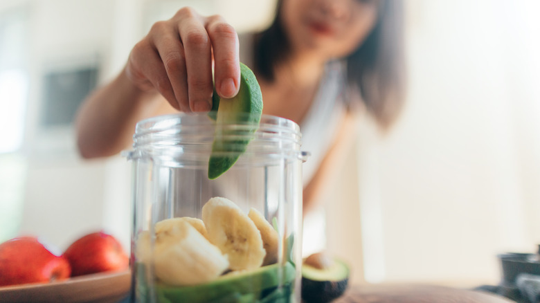 Dropping avocado into a blender