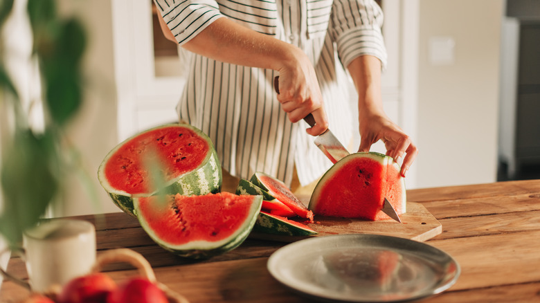 Person slicing fresh watermelon