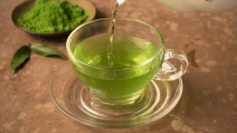 Green tea pouring into cup