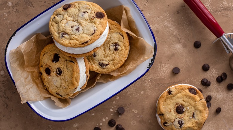 A serving dish filled with a stack of chocolate chip ice cream sandwiches