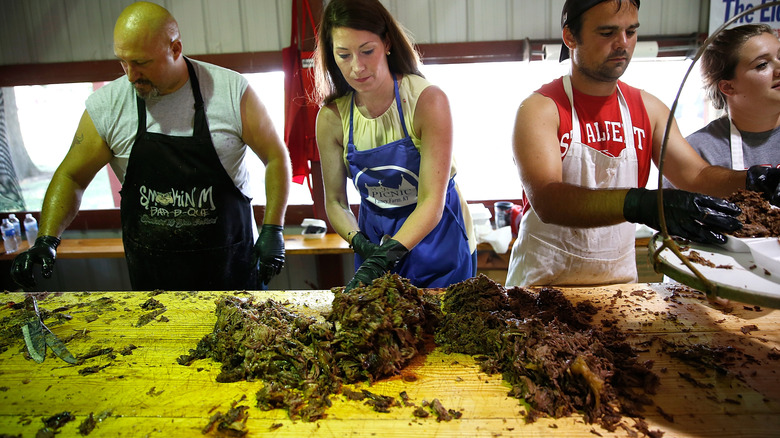 group of people chopping cooked mutton at a large picnic in Kentucky