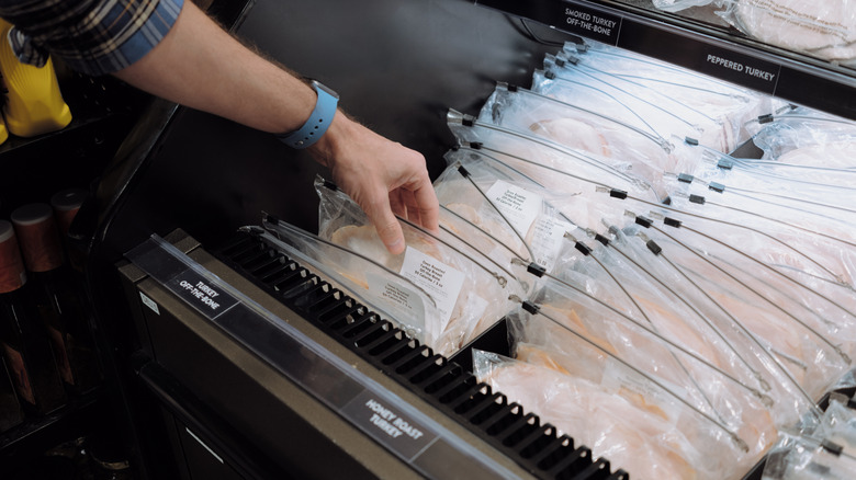 Hand reaching for deli meat