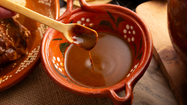 Mole sauce in a clay serving bowl with a spoon