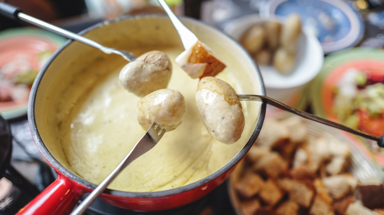 Fondue forks over melted cheese