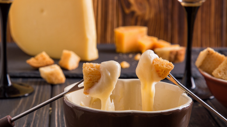 Fondue forks holding cheesy bread