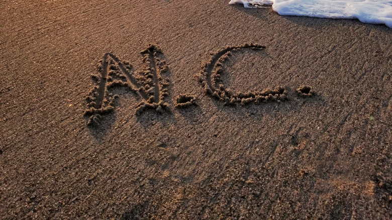 Beach with tide and N.C. written in the sand