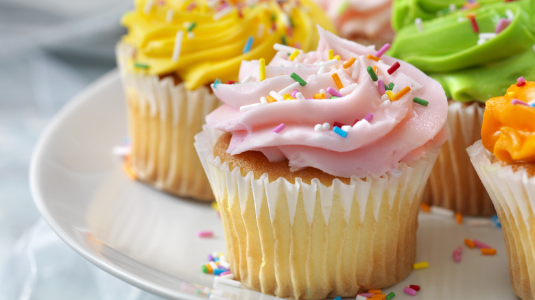 Plate of colorful sprinkle cupcakes
