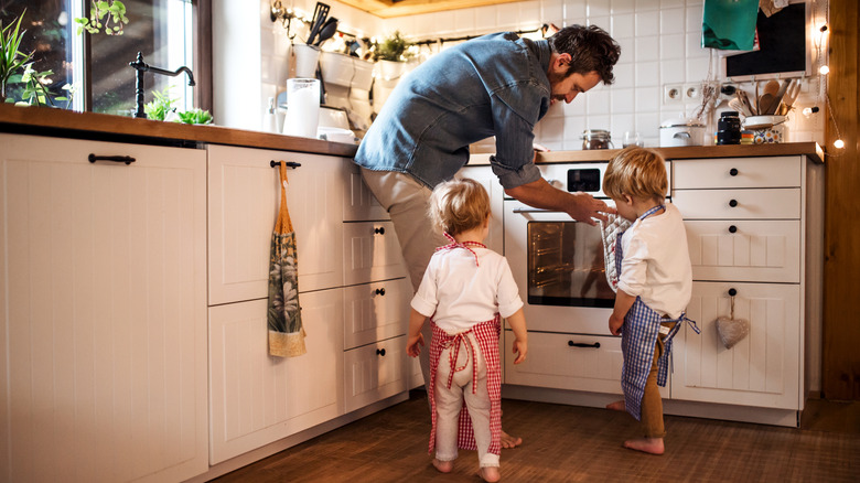 man and kids with oven