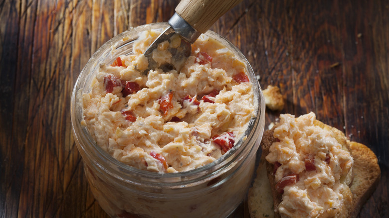 Pimento cheese in a jar with a butter knife