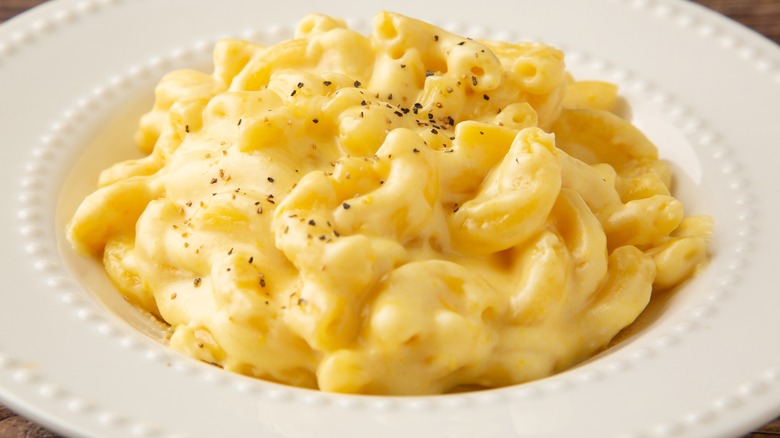 White bowl of macaroni and cheese topped with black pepper