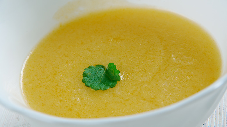 Gravy boat of veloute sauce with parsley garnish