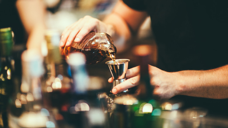 a bartender measuring a jigger