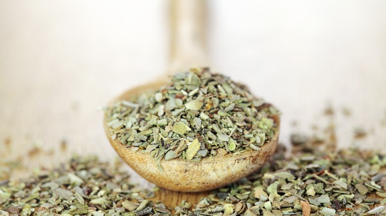 dried oregano in wooden spoon