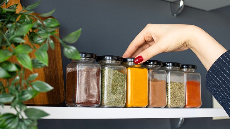 hand holding jars on shelf