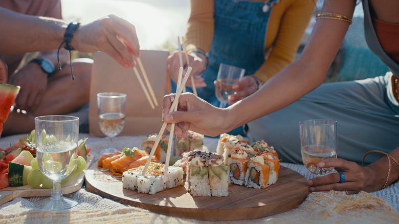 People eating sushi at a picnic 