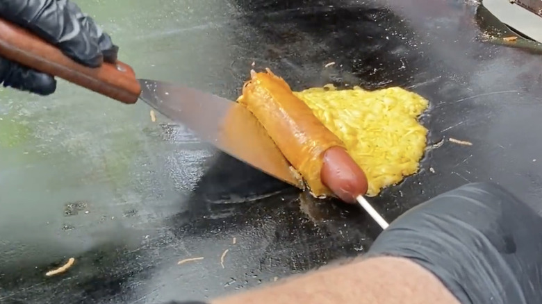 encasing hot dog in cheese on griddle