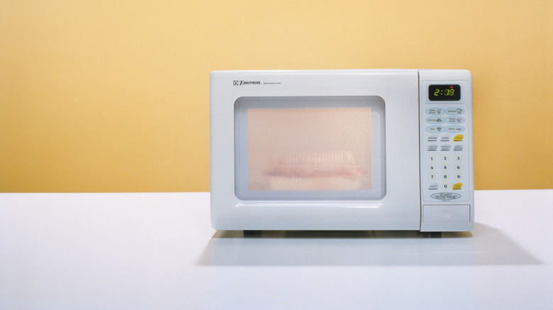 A microwave on a white surface.