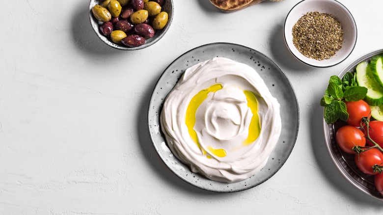 Bowl of labneh with olives and tomatoes