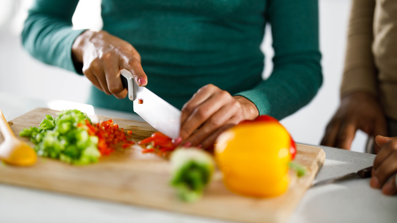 Person finely chopping vegetables
