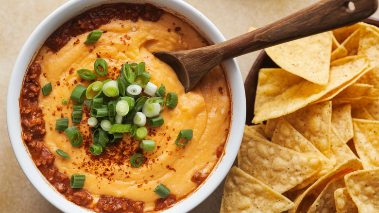 Queso dip with wooden spoon and tortilla chips