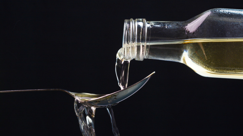 Pouring apple cider vinegar into a spoon