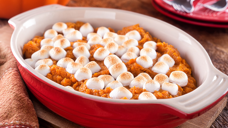 Red casserole dish with marshmallow-topped sweet potatoes