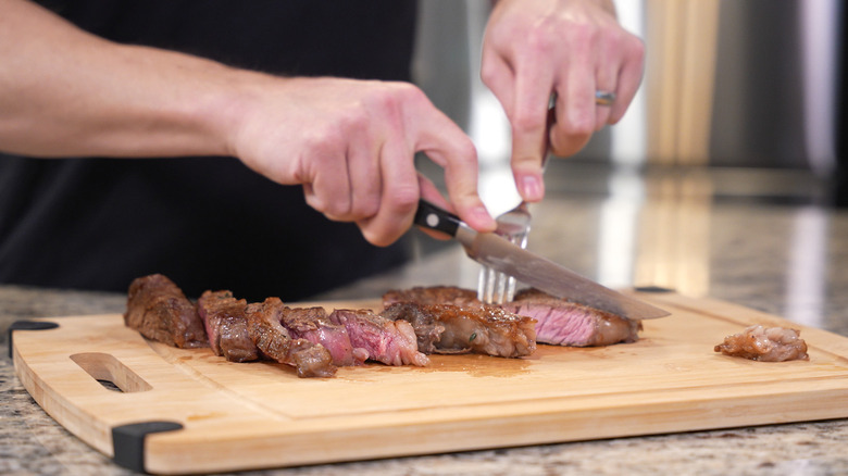 Person cutting seared steak. 