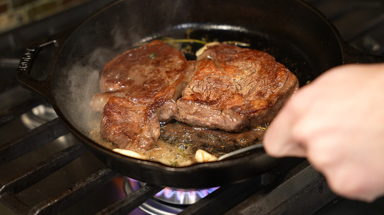 Basting a seared steak with butter.