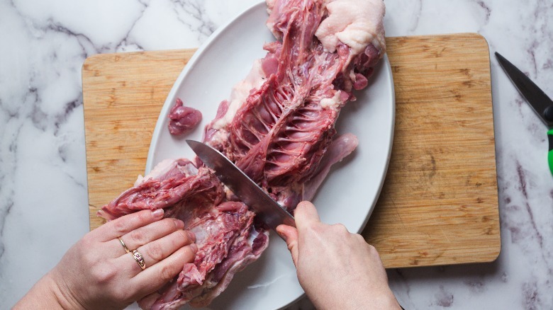 Separating the duck breast from the back